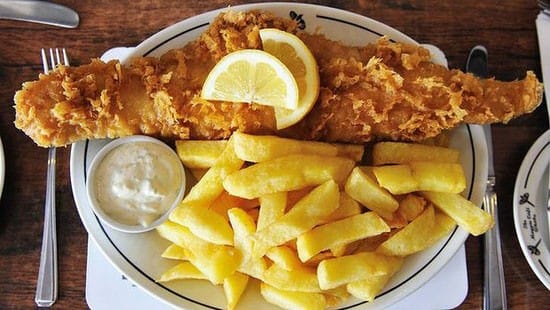 Pescado con patatas típico plato inglés con salsa
